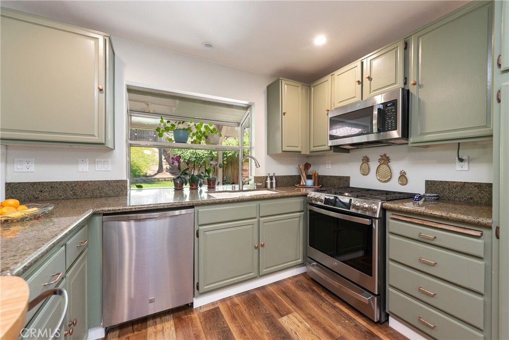 4384 Mill Valley Road Moorpark, CA 93021 - Photo 14 of 32 a kitchen with stainless steel appliances granite countertop a stove a sink and a microwave
