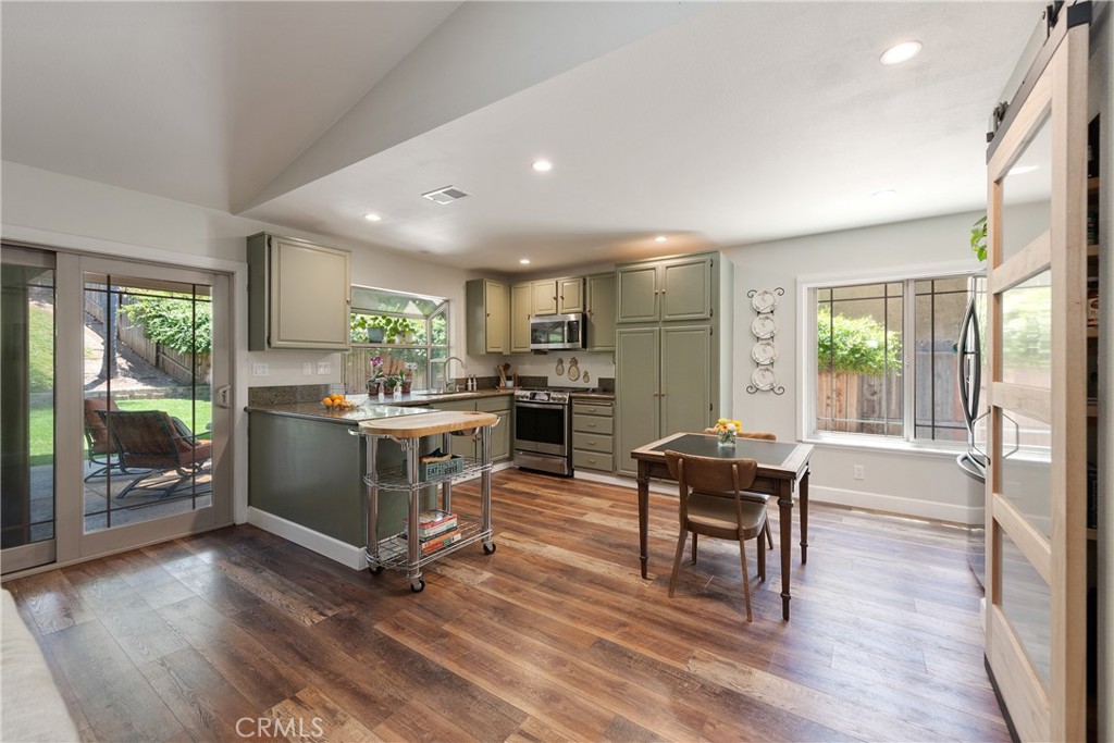 4384 Mill Valley Road Moorpark, CA 93021 - Photo 10 of 32 a kitchen with a table chairs refrigerator and cabinets