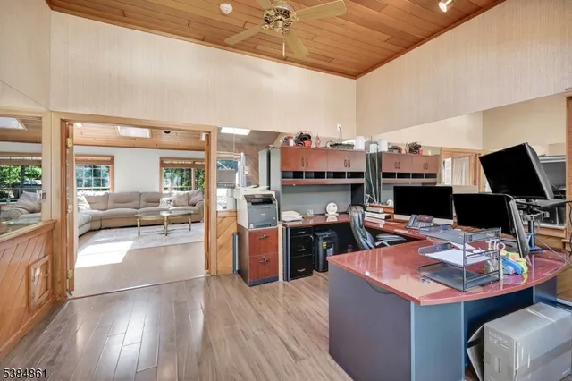 a open kitchen with stainless steel appliances kitchen island granite countertop a sink dishwasher and a stove with wooden floor