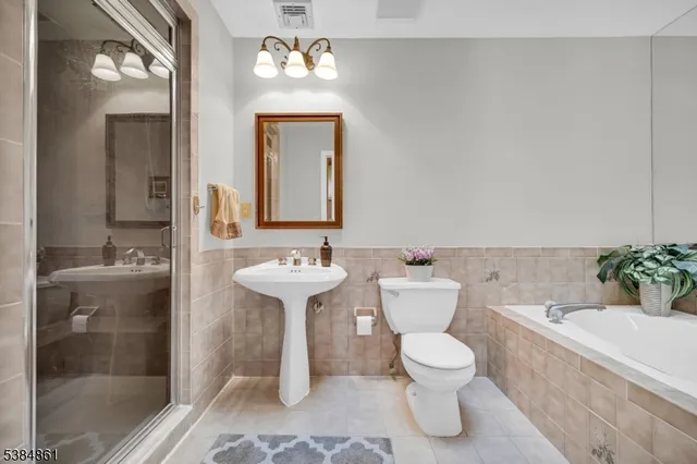 a bathroom with a sink toilet a mirror and shower