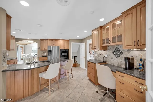 a large kitchen with kitchen island granite countertop a sink and cabinets
