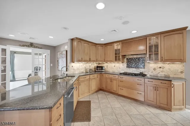 a kitchen with granite countertop sink window and white cabinets
