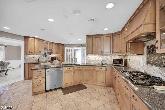 a kitchen with stainless steel appliances granite countertop a stove a sink dishwasher and a refrigerator