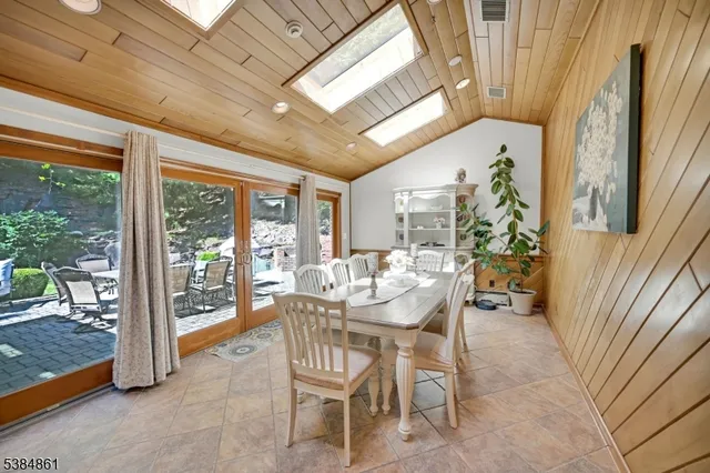 a dining room with furniture and a floor to ceiling window