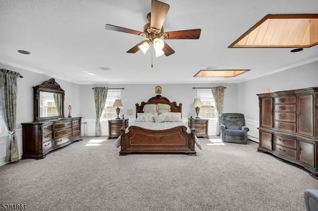 a spacious bedroom with a bed and a chandelier