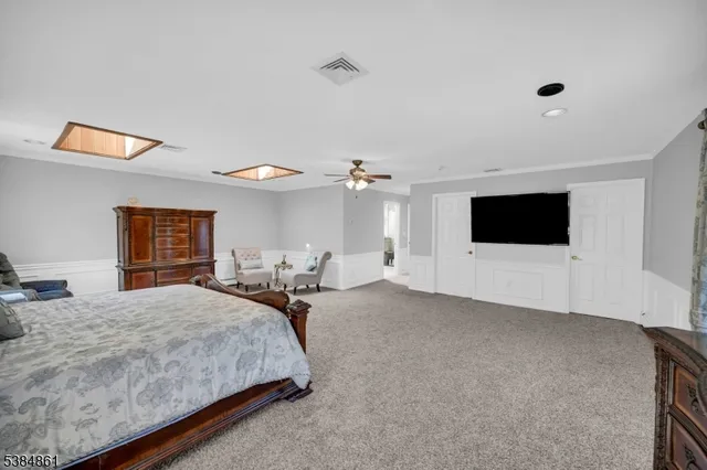 a spacious bedroom with a bed and a flat screen tv