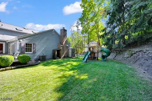 a view of a house with backyard and a tree