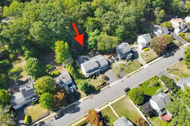 an aerial view of a house with a yard and a wooden fence