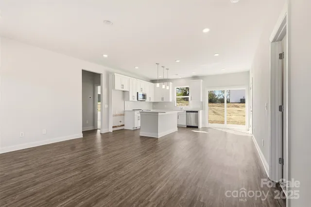 a view of a kitchen with wooden floor and windows