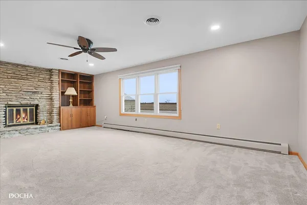 a bedroom with a bed couch and windows