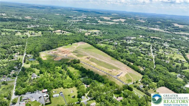 an aerial view of residential houses with outdoor space and trees