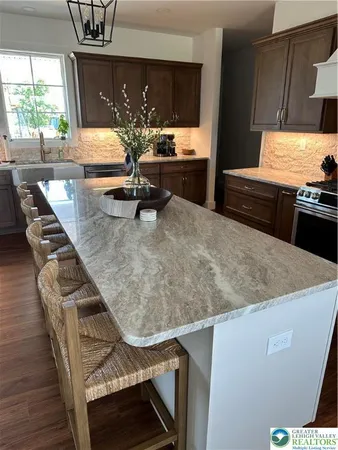 a kitchen with kitchen island granite countertop stainless steel appliances and a chandelier