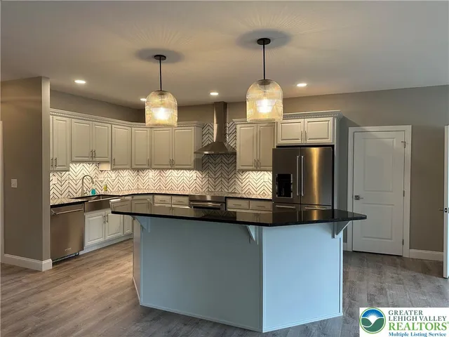 a kitchen with kitchen island granite countertop stainless steel appliances a sink stove and cabinets