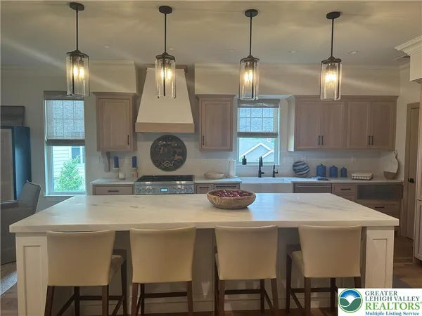 a kitchen with stainless steel appliances granite countertop a sink a stove a refrigerator and white cabinets