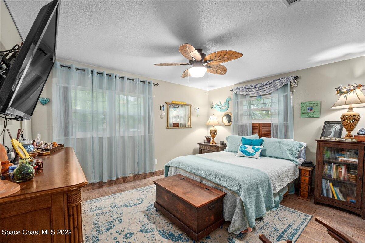 960 Kings Post Road Rockledge, FL 32955 - Photo 14 of 39 a bedroom with a bed and a chandelier