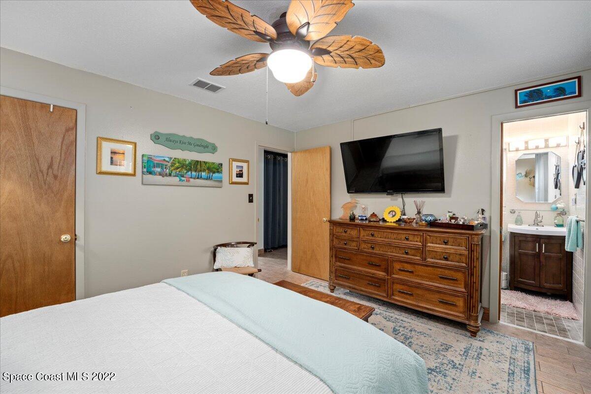 960 Kings Post Road Rockledge, FL 32955 - Photo 15 of 39 a bedroom with a bed and a flat tv screen on dresser