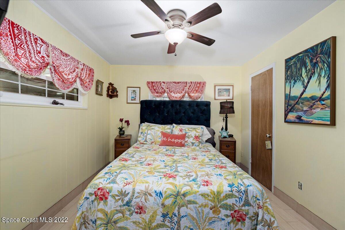 960 Kings Post Road Rockledge, FL 32955 - Photo 18 of 39 a bedroom with a bed and a chandelier