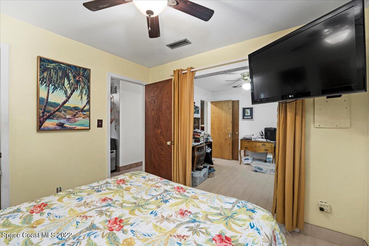 960 Kings Post Road Rockledge, FL 32955 - Photo 19 of 39 a bedroom with a bed and a flat screen tv