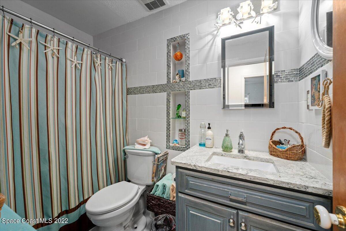 960 Kings Post Road Rockledge, FL 32955 - Photo 20 of 39 a bathroom with a granite countertop toilet sink and mirror