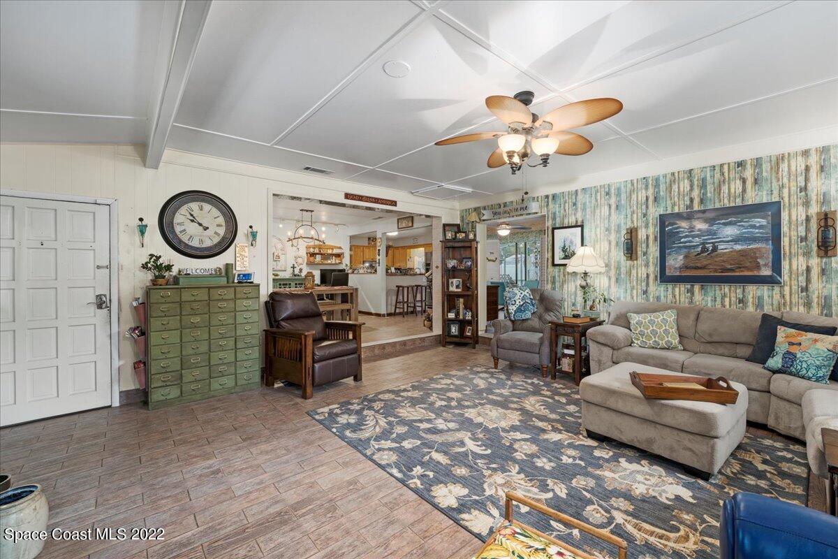 960 Kings Post Road Rockledge, FL 32955 - Photo 6 of 39 a living room with furniture a chandelier and a large window