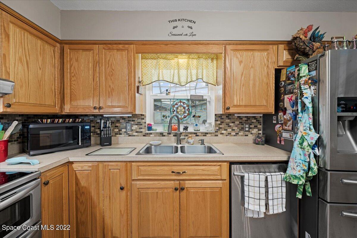 960 Kings Post Road Rockledge, FL 32955 - Photo 8 of 39 a kitchen with stainless steel appliances a sink window and a counter top space
