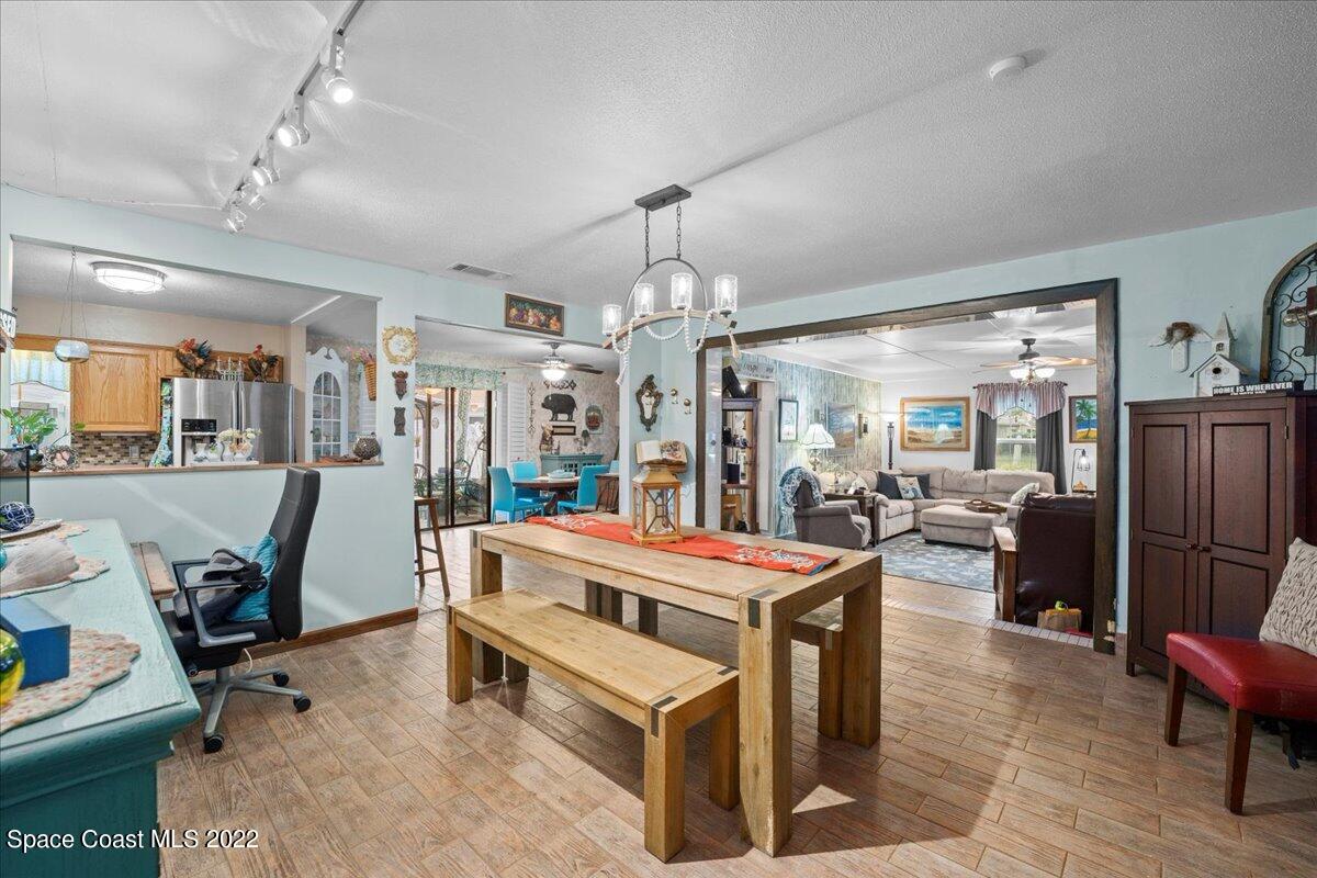960 Kings Post Road Rockledge, FL 32955 - Photo 10 of 39 a room with lots of tables a chandelier and kitchen view
