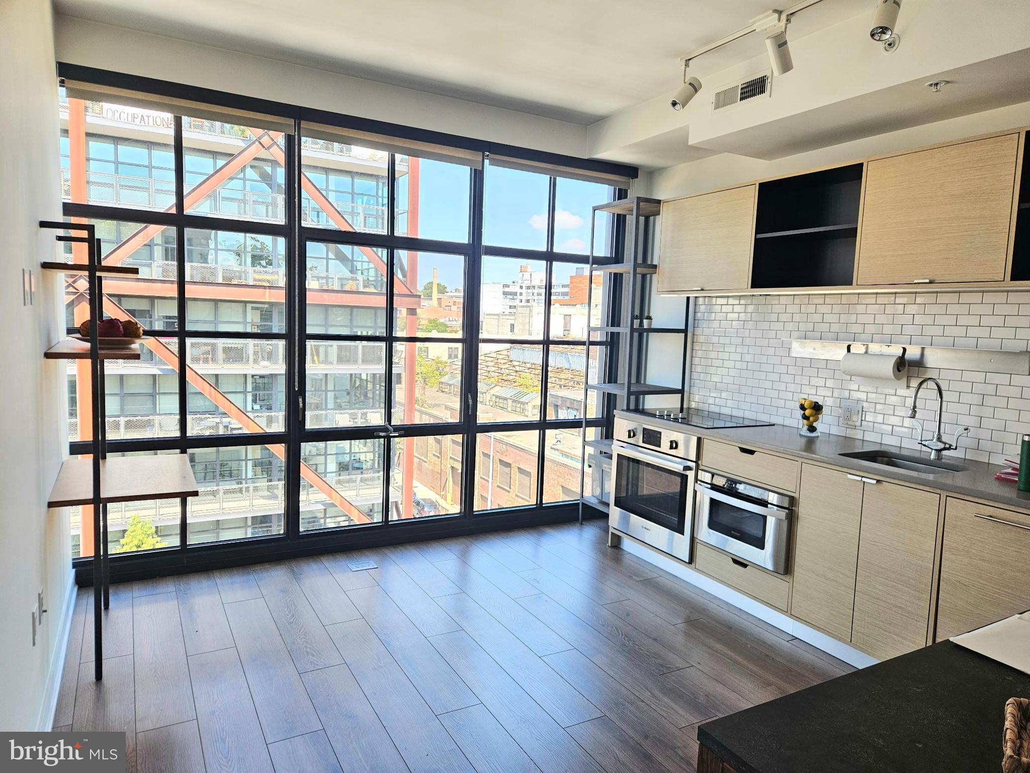 2030 8th Street Northwest, Unit PH5 Washington, DC 20001 - Photo 3 of 20 a kitchen with stainless steel appliances wooden floor and a large window