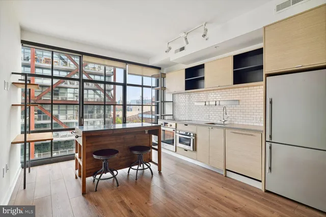 a kitchen with a table chairs refrigerator and cabinets