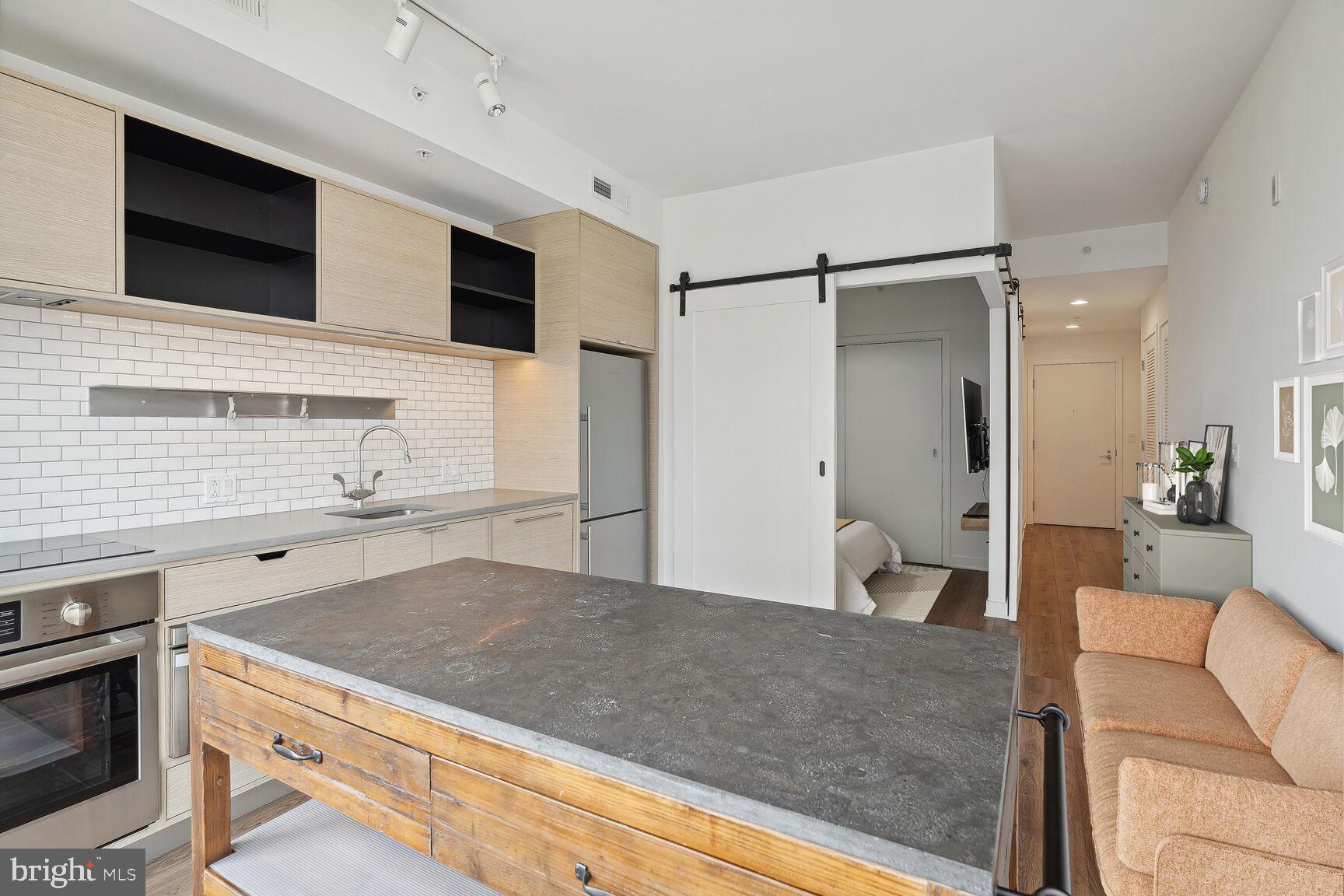 2030 8th Street Northwest, Unit PH5 Washington, DC 20001 - Photo 5 of 20 a living room with stainless steel appliances kitchen island granite countertop a refrigerator and a stove top oven