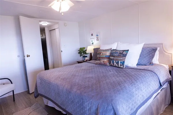 a bedroom with a bed a chandelier and dresser