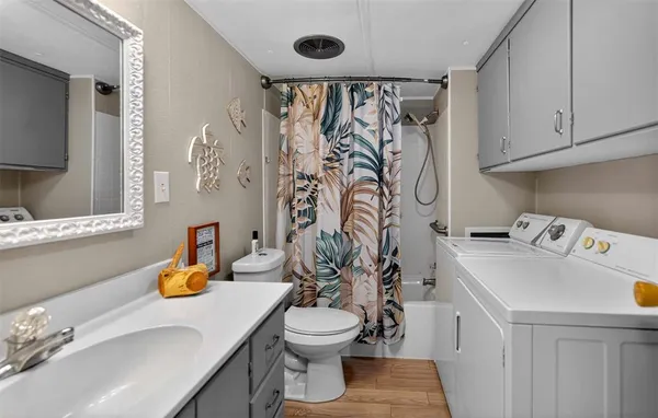 a bathroom with a sink a toilet and shower curtain