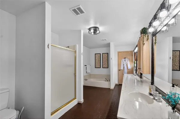 a view of a hallway with bathroom and wooden floor