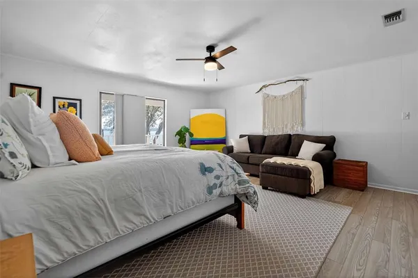 a spacious bedroom with a bed and ceiling fan