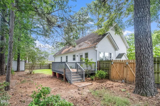 a view of a house with a yard and large tree