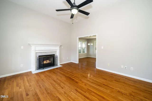 a view of empty room with wooden floor and a fireplace
