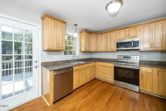 a kitchen with granite countertop wooden floors and stainless steel appliances