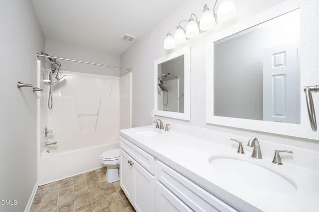 a bathroom with a granite countertop sink a toilet a mirror and shower