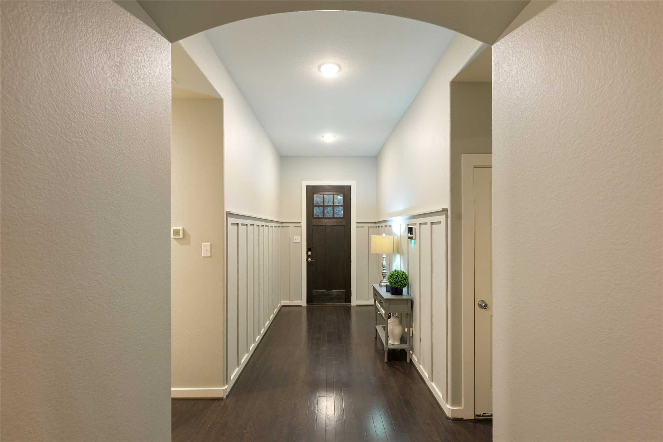 188 Nautical Loop Kyle, TX 78640 - Photo 5 of 38 A welcoming entryway features rich hardwood floors, wainscoting, and recessed lighting leading to a dark wood front door.
