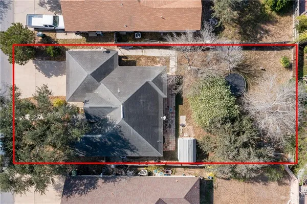an aerial view of a house with a yard and large trees