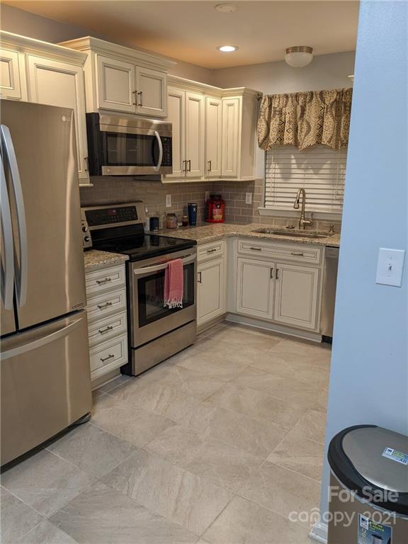 5030 Gibbons Link Road Charlotte, NC 28269 - Photo 5 of 28 a kitchen with stainless steel appliances a stove a sink and a refrigerator