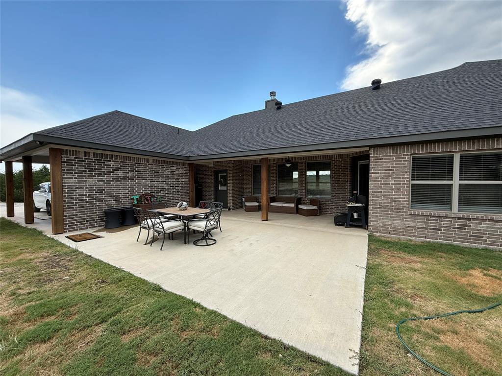 2455 Schooner Way Bluff Dale, TX 76433 - Photo 36 of 37 Back of property with roof with shingles, a patio, and brick siding