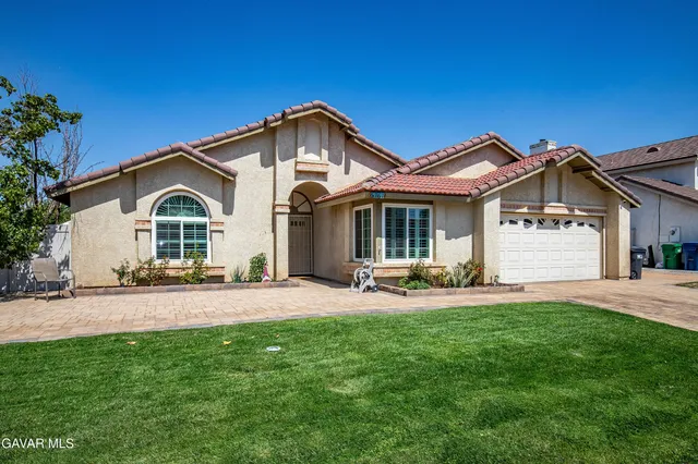 a front view of a house with a garden and yard