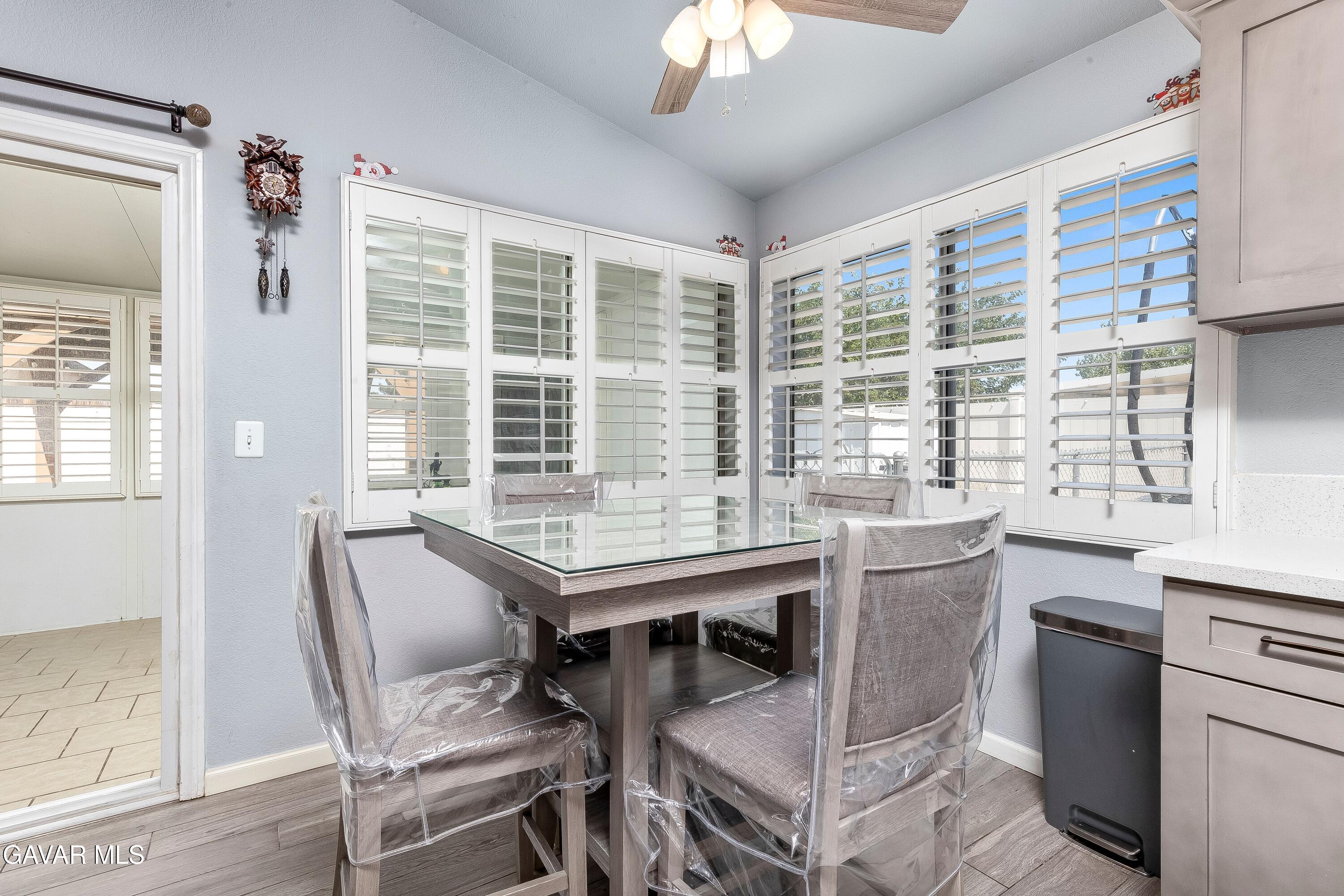 5767 East Ave R 11 Palmdale, CA 93552 - Photo 11 of 27 a view of a dining room with furniture large windows and wooden floor