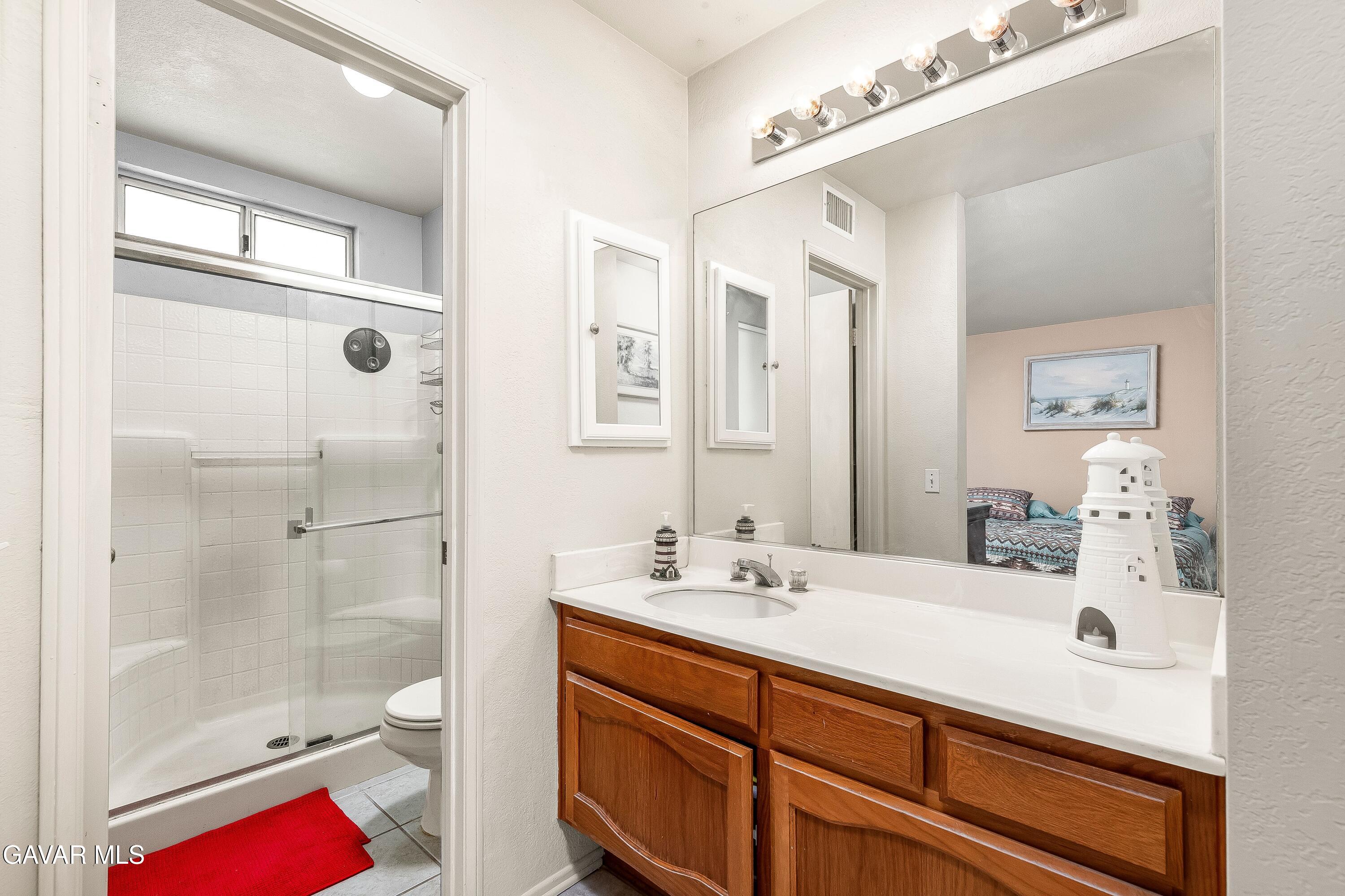 5767 East Ave R 11 Palmdale, CA 93552 - Photo 13 of 27 a bathroom with a shower sink vanity mirror and shower