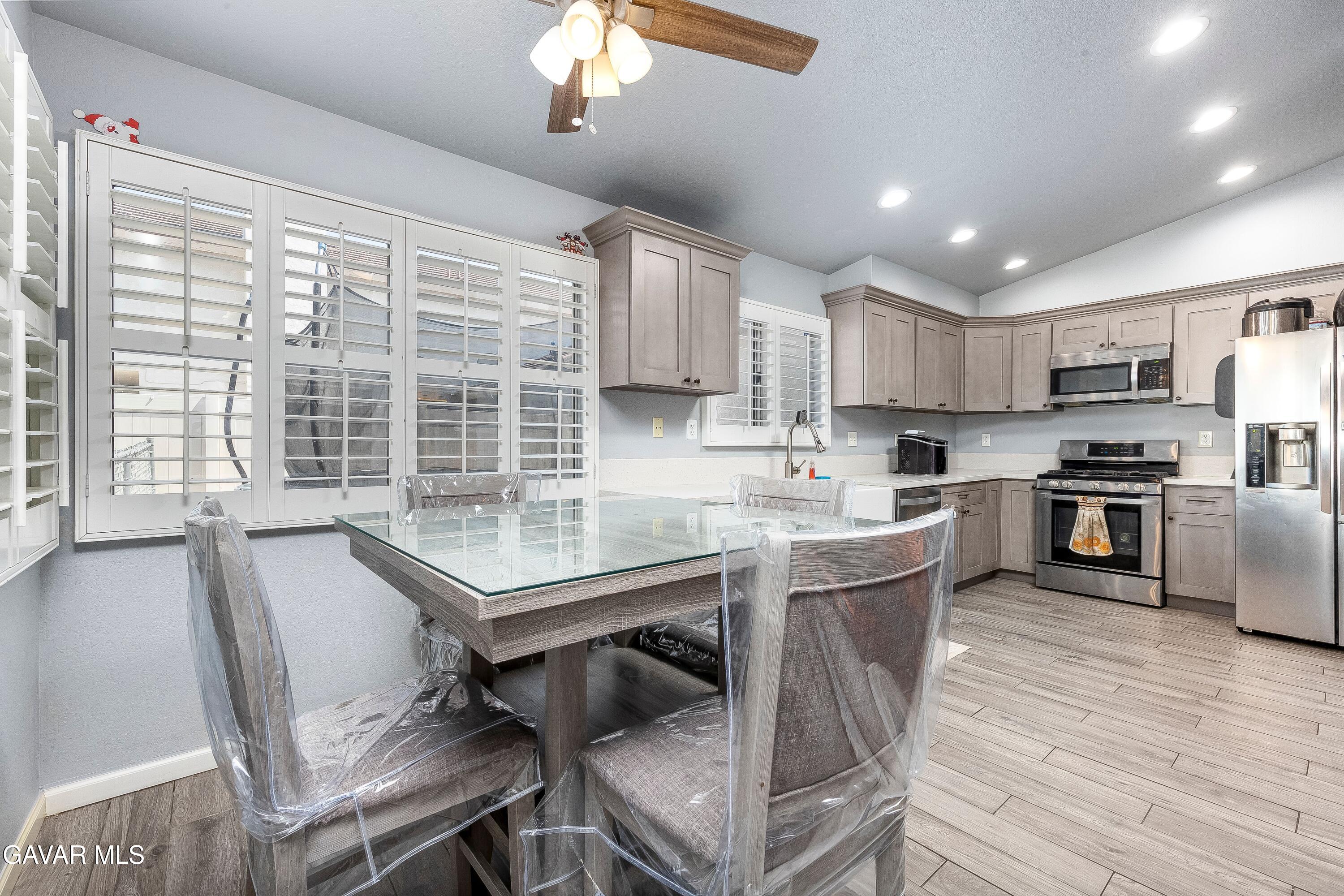 5767 East Ave R 11 Palmdale, CA 93552 - Photo 9 of 27 a kitchen with a table chairs stainless steel appliances and cabinets