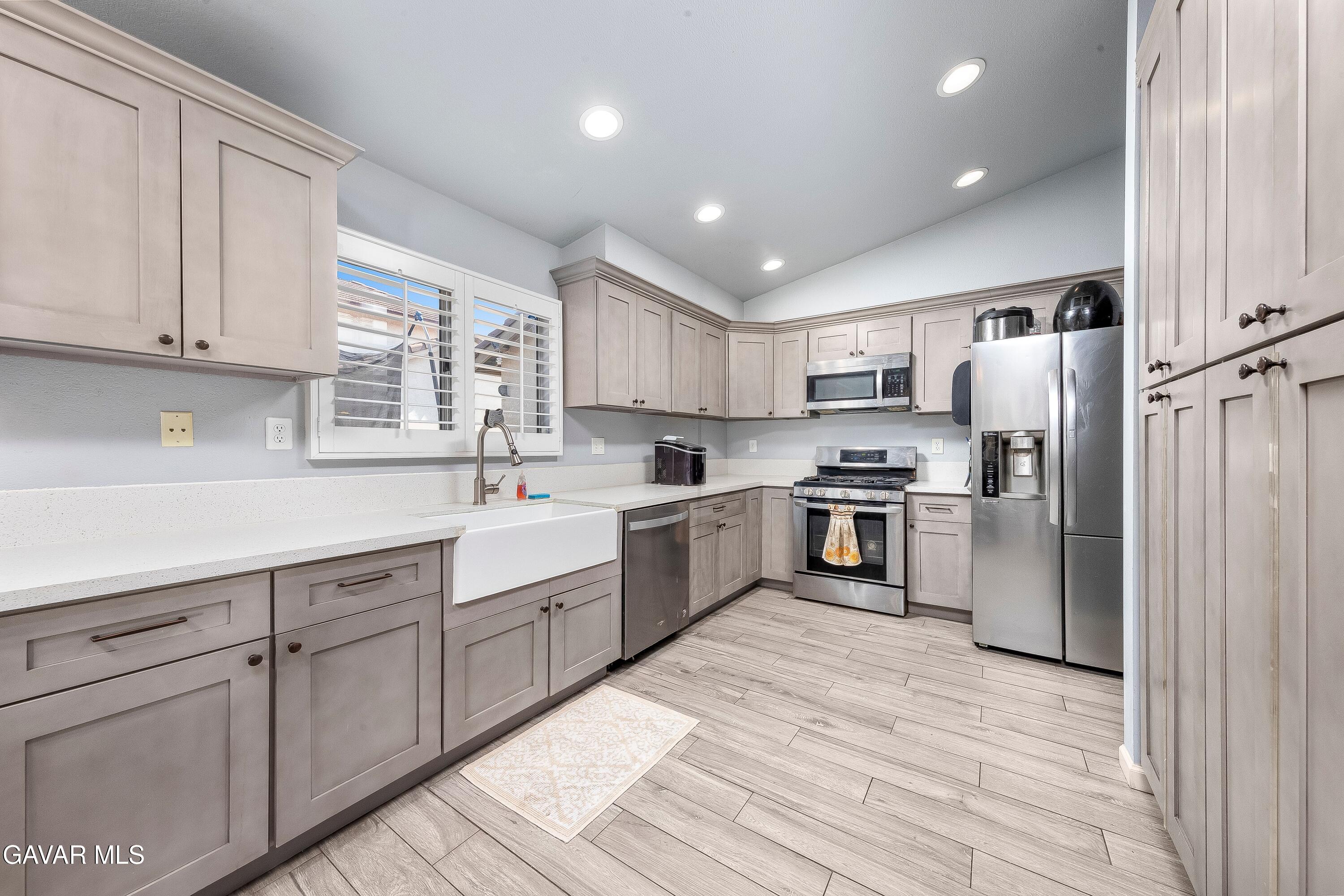 5767 East Ave R 11 Palmdale, CA 93552 - Photo 10 of 27 a kitchen with stainless steel appliances granite countertop a refrigerator sink and cabinets