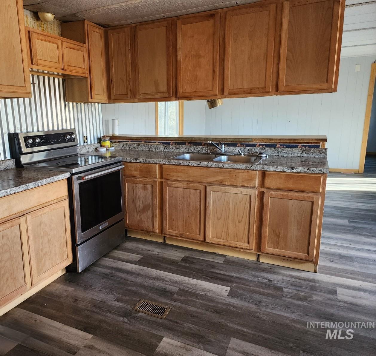 1853 McLay Road Vale, OR 97918 - Photo 1 of 8 Kitchen featuring dark wood finished floors, stainless steel electric stove, wood finish cabinets, and wood walls