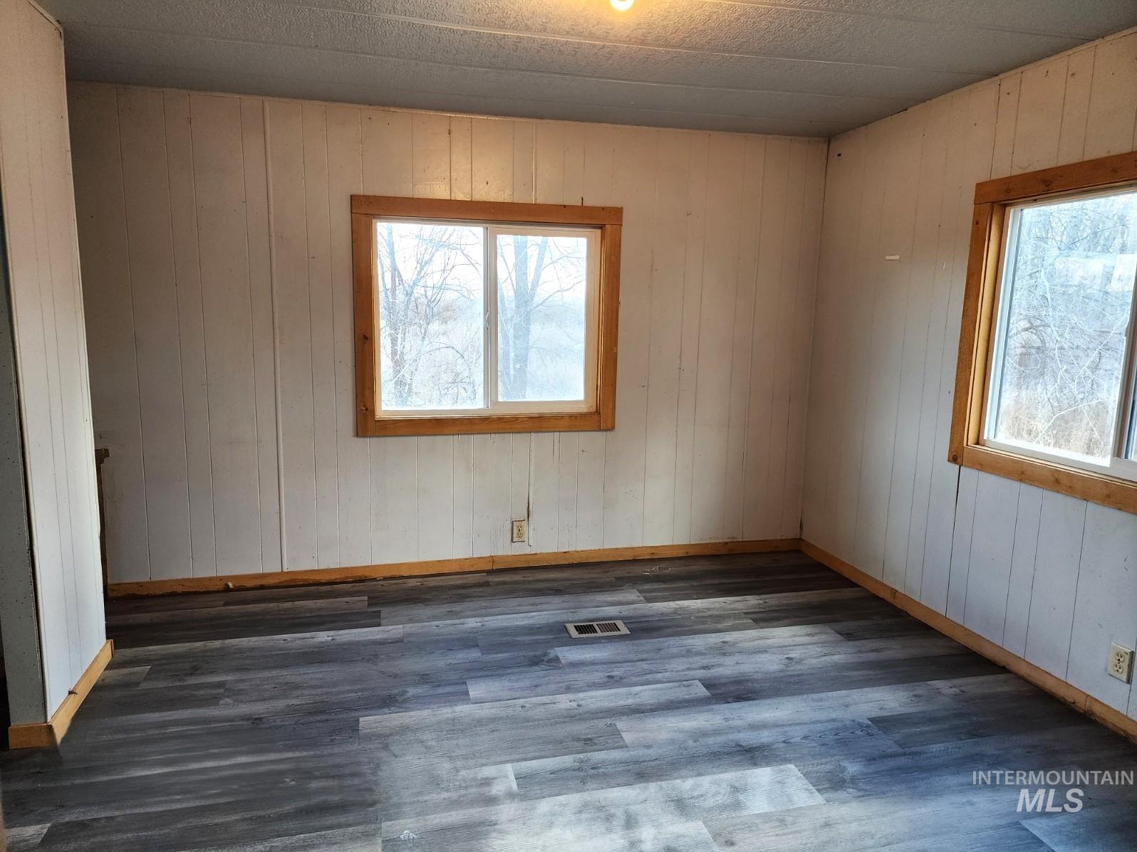 1853 McLay Road Vale, OR 97918 - Photo 6 of 8 Unfurnished room with wood walls, dark wood-style flooring, and healthy amount of natural light