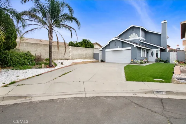 front view of house with a yard and potted plants