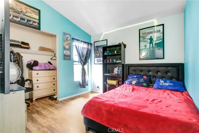 a bedroom with a bed and wooden floor